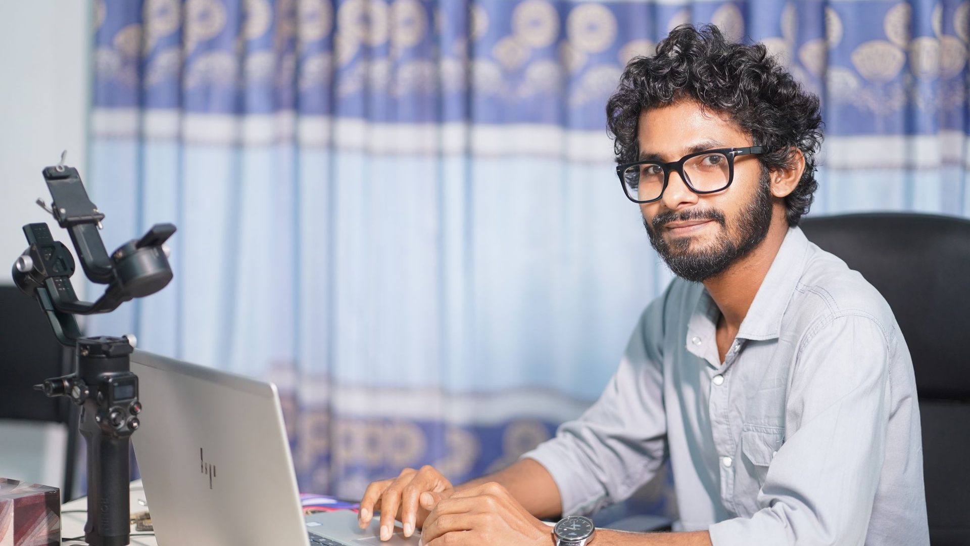Homem concentrado a trabalhar num portátil, num ambiente de escritório moderno